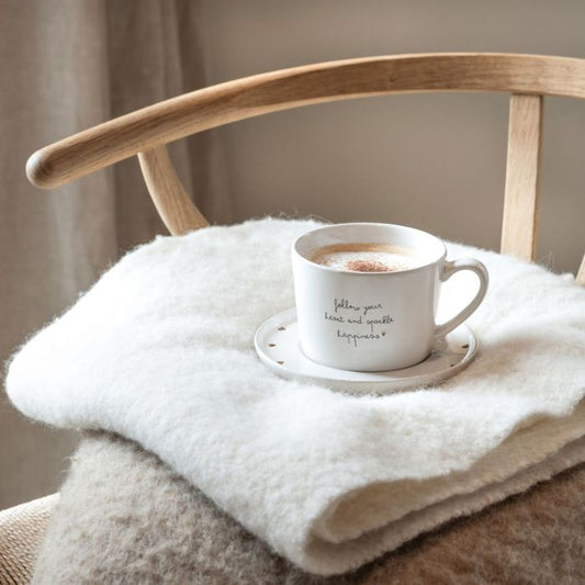 Bastion Collections Tasse Weiss mit dem Schriftzug Follow you Heart and Sparkle Happiness mit Kaffee in Szene gesetzt.