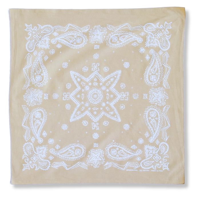 Detailaufnahme des handgezeichneten Paisley-Siebdrucks auf sandfarbener Baumwolle mit präzisem Rollsaum.