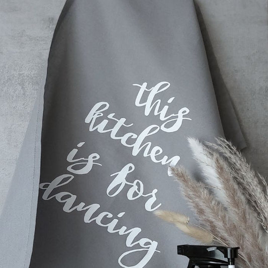 Graues Geschirr Tuch mit dem Spruch "This kitchen is for dancing" in Siebdruck