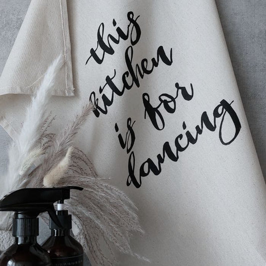 Naturfarbenes Geschirr Tuch mit dem Spruch "This kitchen is for dancing" in Siebdruck