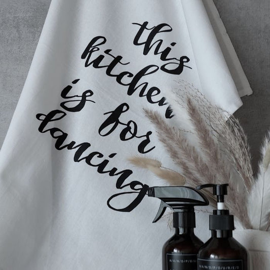 Weißes Geschirr Tuch mit dem Spruch "This kitchen is for dancing" in Siebdruck