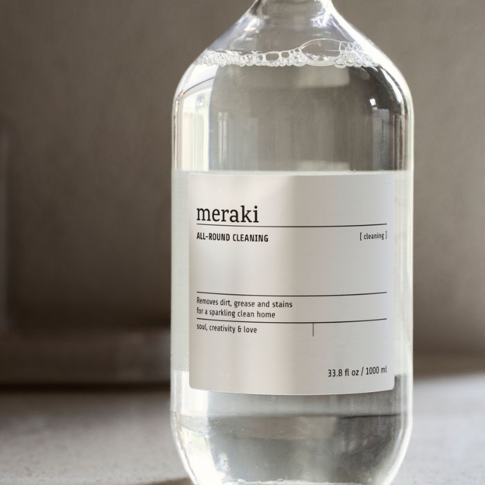 Hand hält Meraki Allzweckreiniger Klar Flasche mit Zitrus-Blumen-Duft