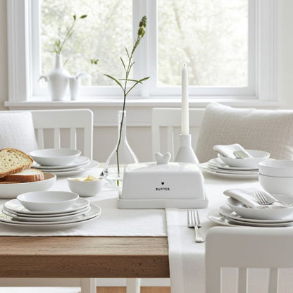 Bastion Collections Butterdose Fleet Weiss mit schwarzem Herz auf einem gedeckten Tisch in hellem Ambiente