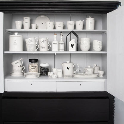 Bastion Collections Eierbecher Weiss mit schwarzem Herz dekorativ in einem Schrank platziert