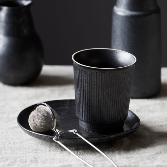 Tasse Berica von House Doctor auf gedecktem Tisch mit dunklem Geschirr