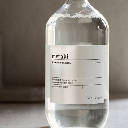 Hand hält Meraki Allzweckreiniger Klar Flasche mit Zitrus-Blumen-Duft